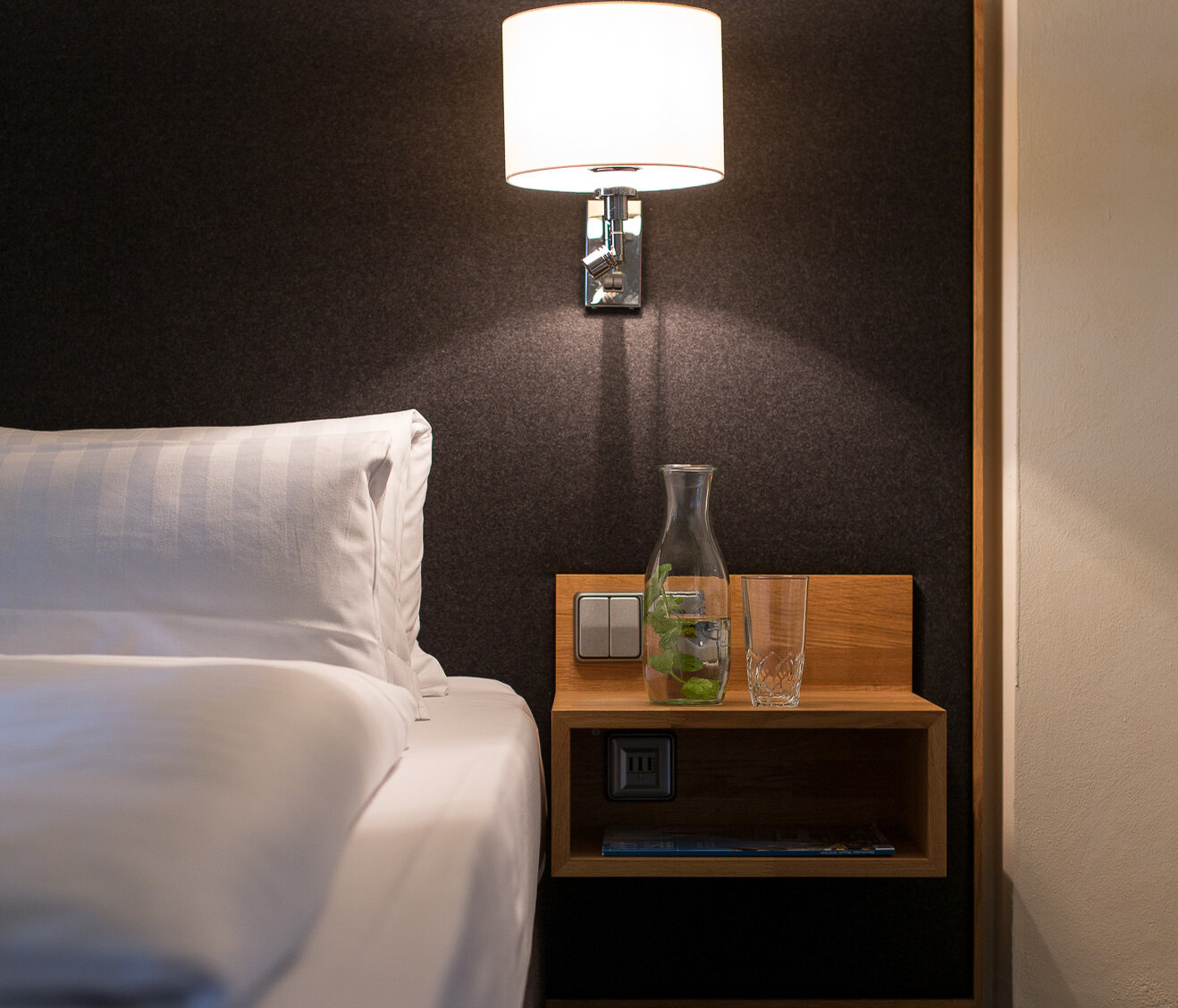 Detailansicht eines Nachttischs mit Lampe und Bett im Hotelzimmer des Hotel-Landgasthof KREUZ