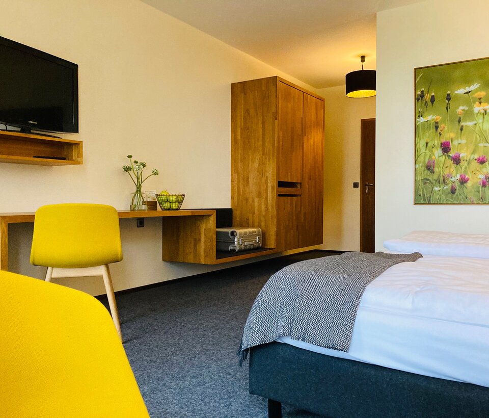 Gemütliches Doppelzimmer mit Holzmöbeln und Fenster zur grünen Umgebung im Hotel-Landgasthof KREUZ