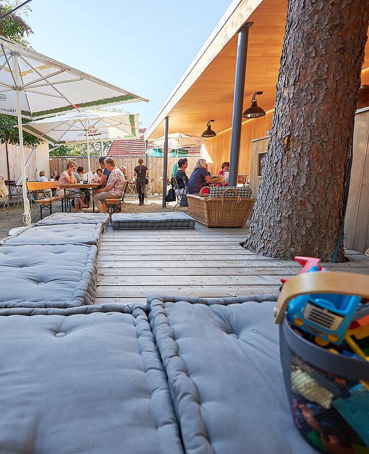 Außenbereich mit Terrasse, gedeckten Tischen und Sonnenschirmen