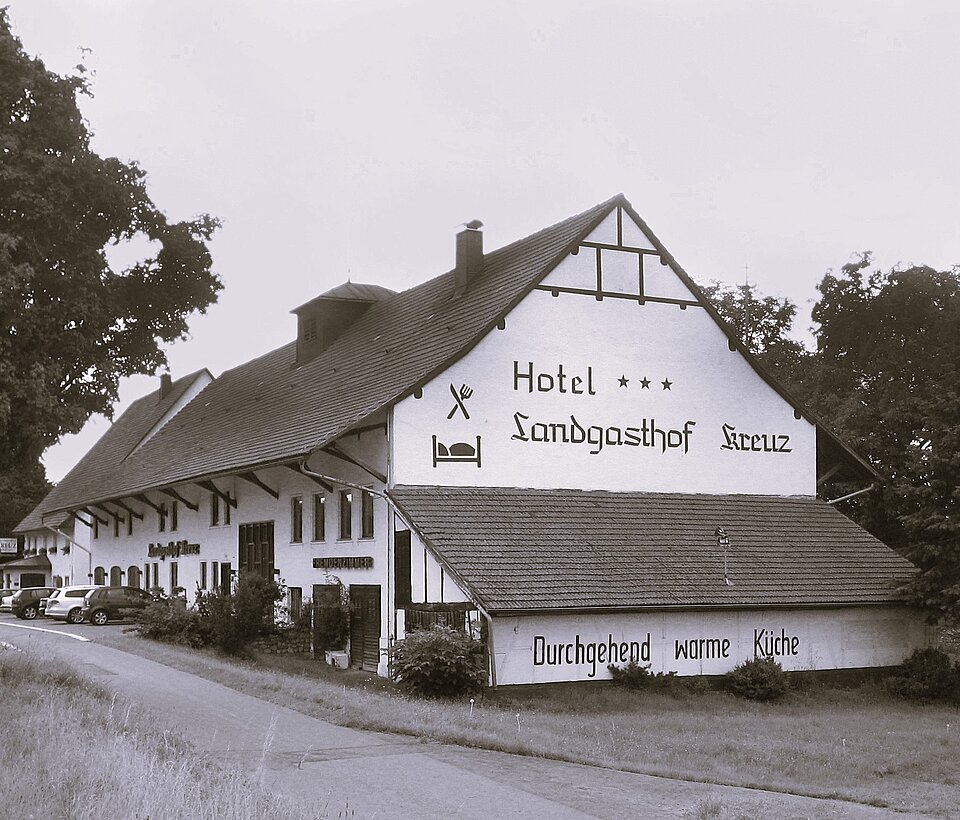 Alte Ansicht eines Gasthauses mit großem Giebel und Fachwerk