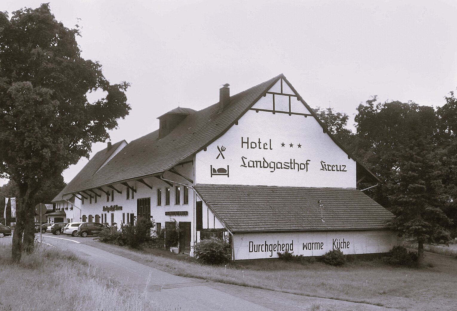 Alte Ansicht eines Gasthauses mit großem Giebel und Fachwerk