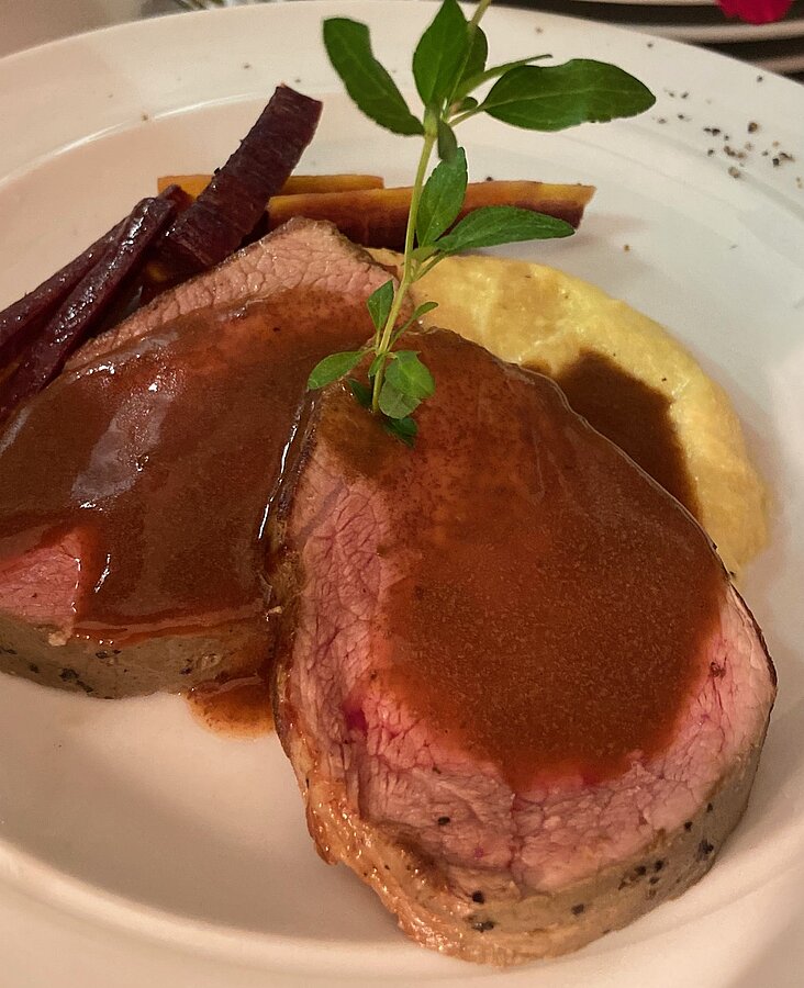 Hauptgericht mit gebratenem Fleisch, Soße und Beilage